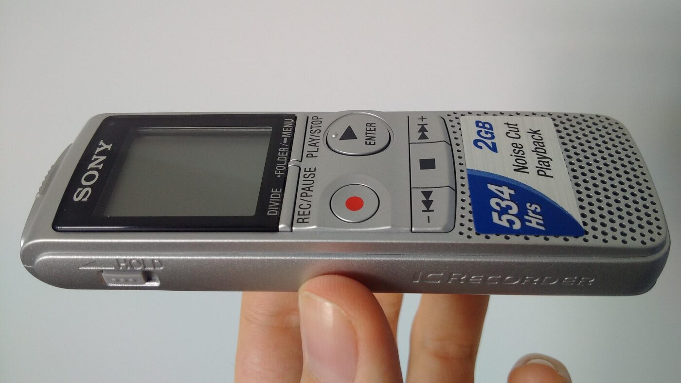 A handheld digital voice recorder with a small screen and record and playback buttons