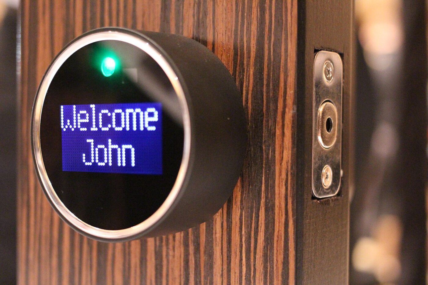 A smart lock with a small display mounted on a wooden door
