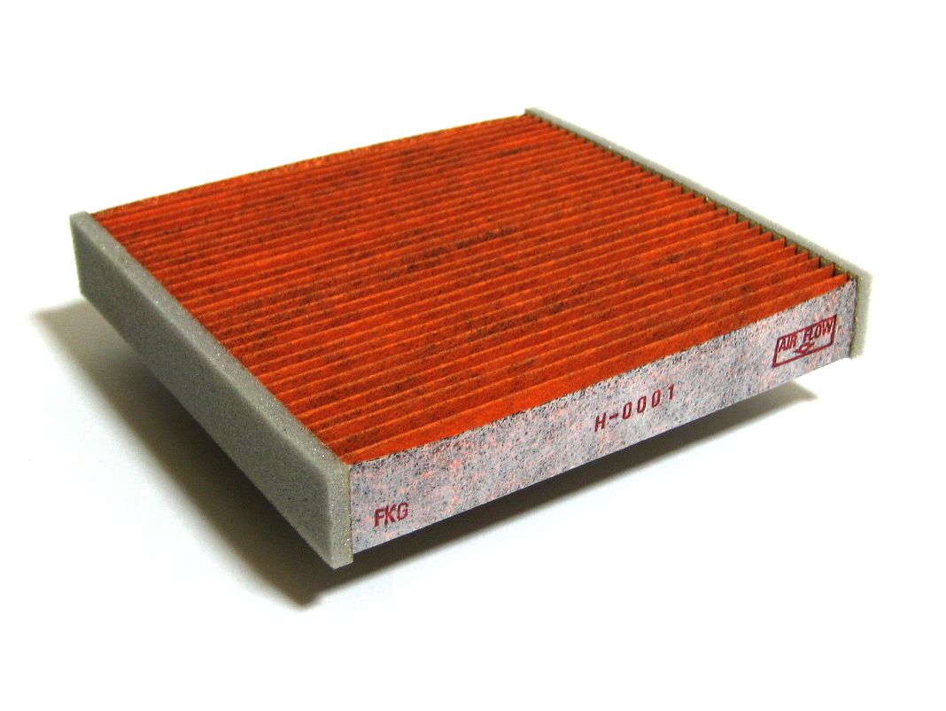 A pleated cabin air filter panel in its frame, photographed on a white background
