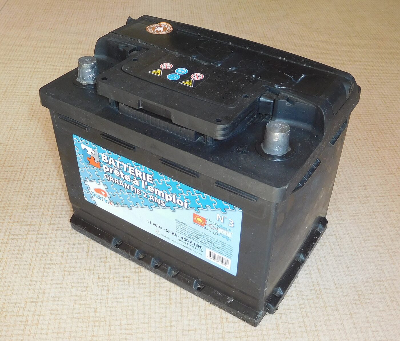 A sealed lead-acid car battery with its two terminals, photographed out of the car