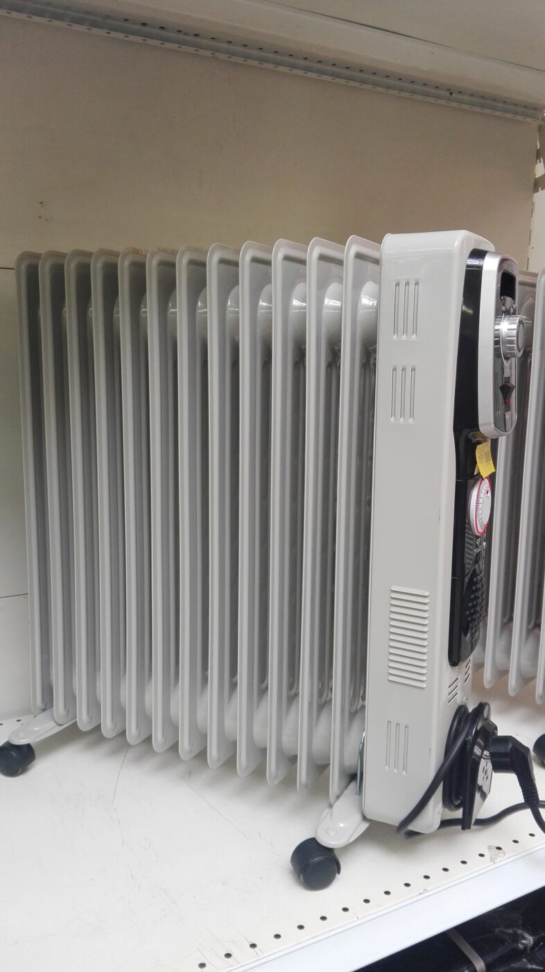 A white oil-filled column radiator on castors, its controls and cord at one end.