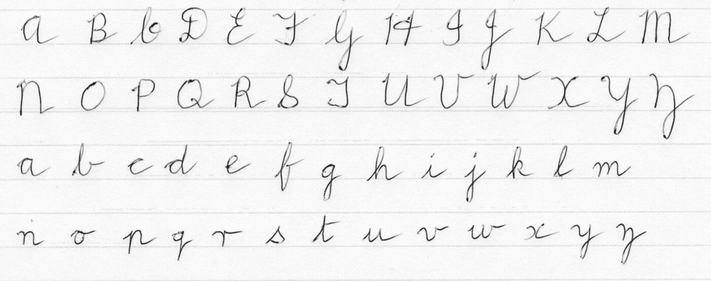 A looped cursive alphabet written in upper and lower case on ruled paper.