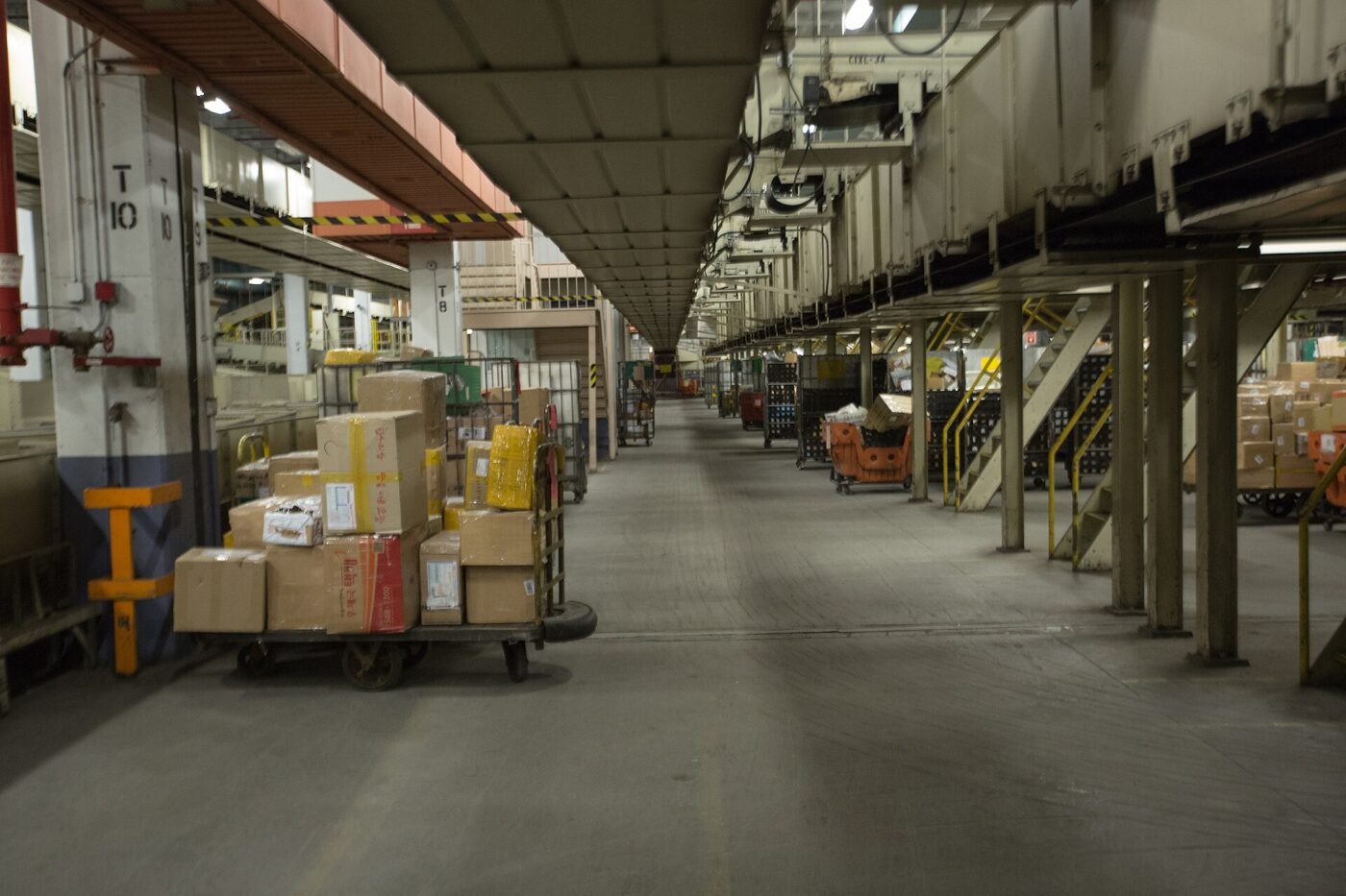 Parcels stacked along an aisle at the JFK International Mail Facility