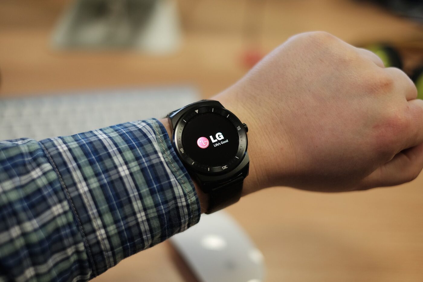 A round-faced LG smartwatch with its screen lit, worn on a wrist