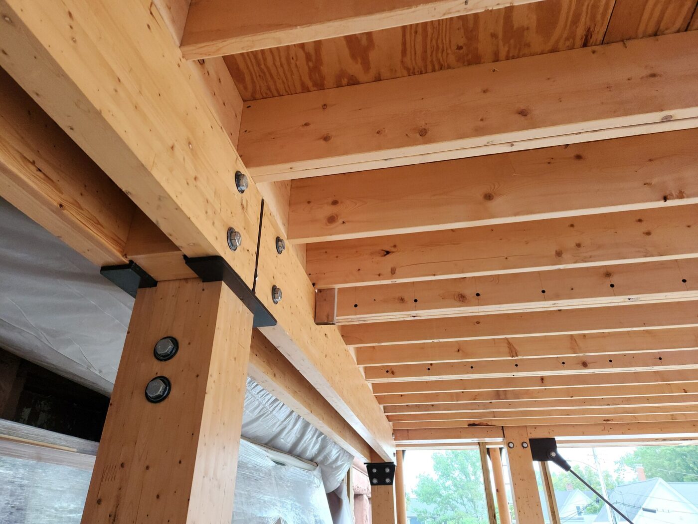New softwood framing lumber and beams overhead in a building under construction.