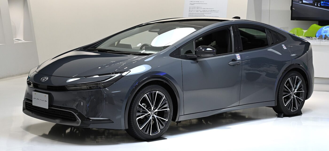 A gray Toyota hybrid hatchback on display in a bright white showroom