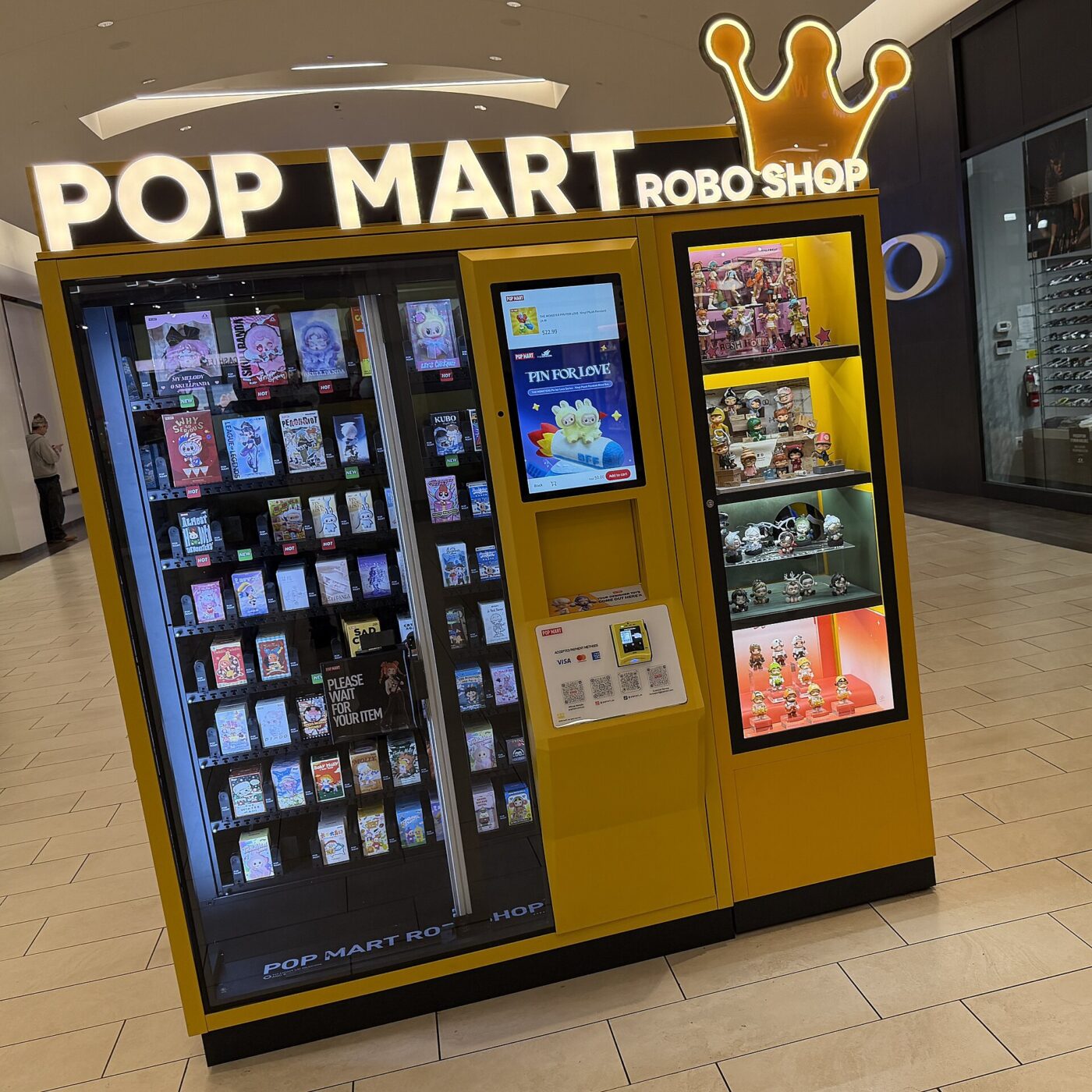A Pop Mart Robo Shop vending machine stocked with boxed collectible figures inside a shopping mall