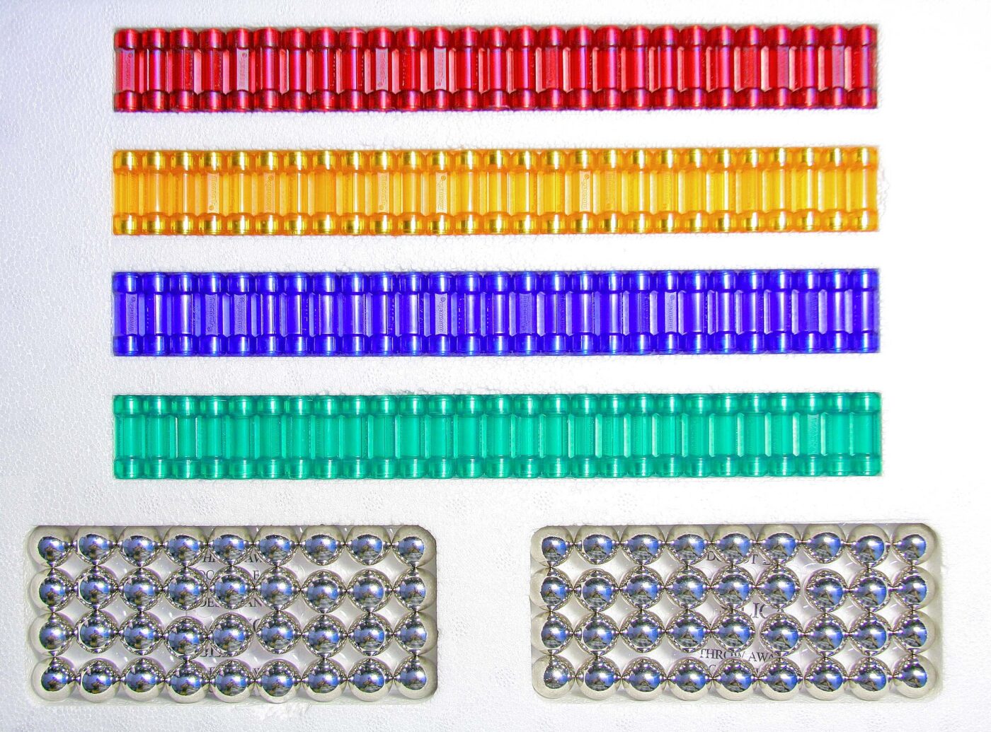 Colored magnetic rods and trays of small steel balls from a construction set.