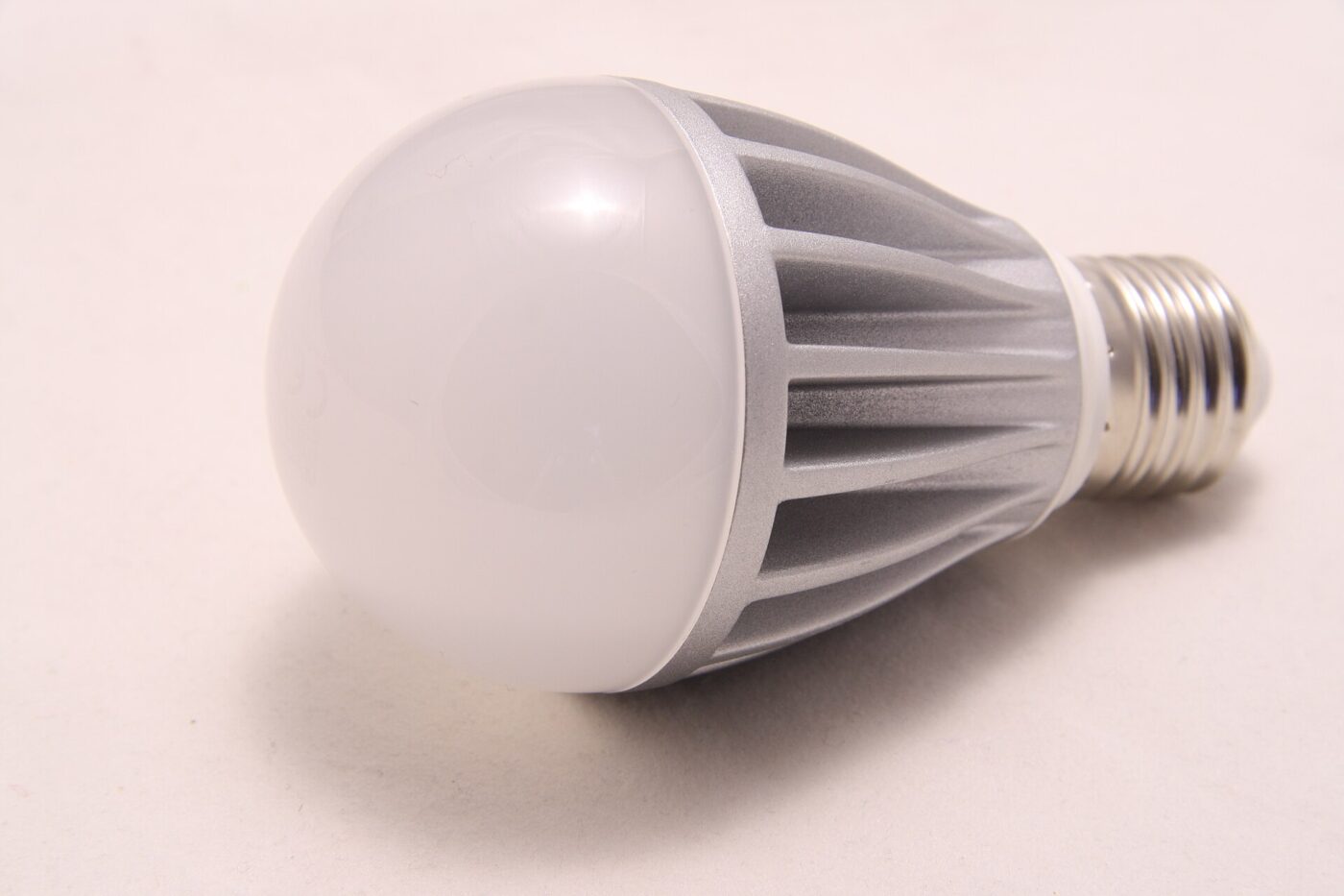 A screw-base LED bulb with a finned aluminum heat sink on a white background.