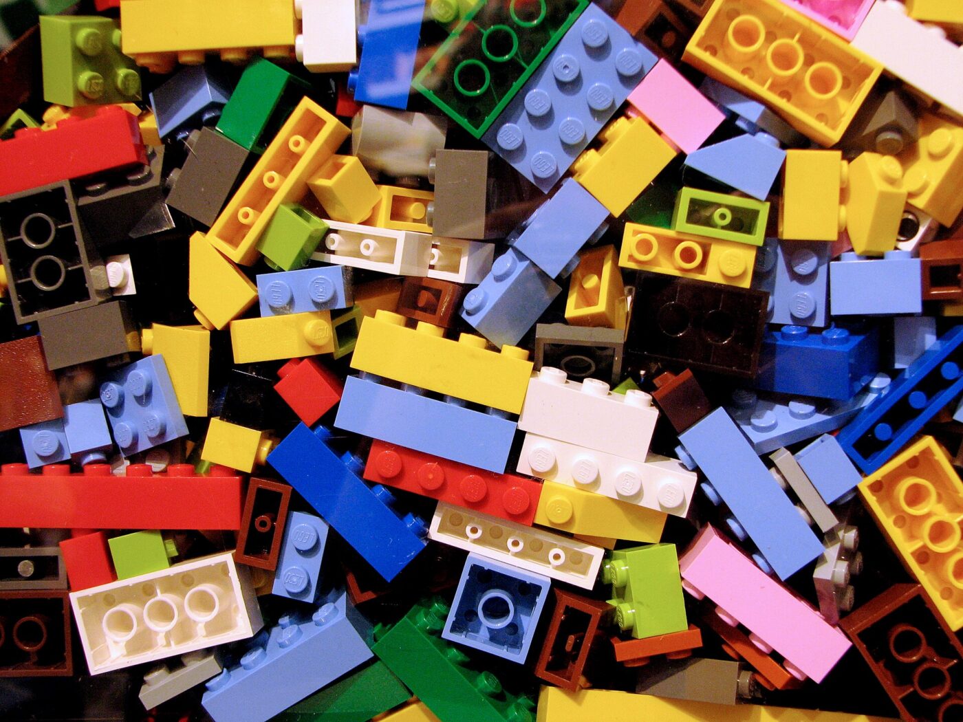 A close-up of assorted LEGO bricks in many colors, shapes and sizes piled together