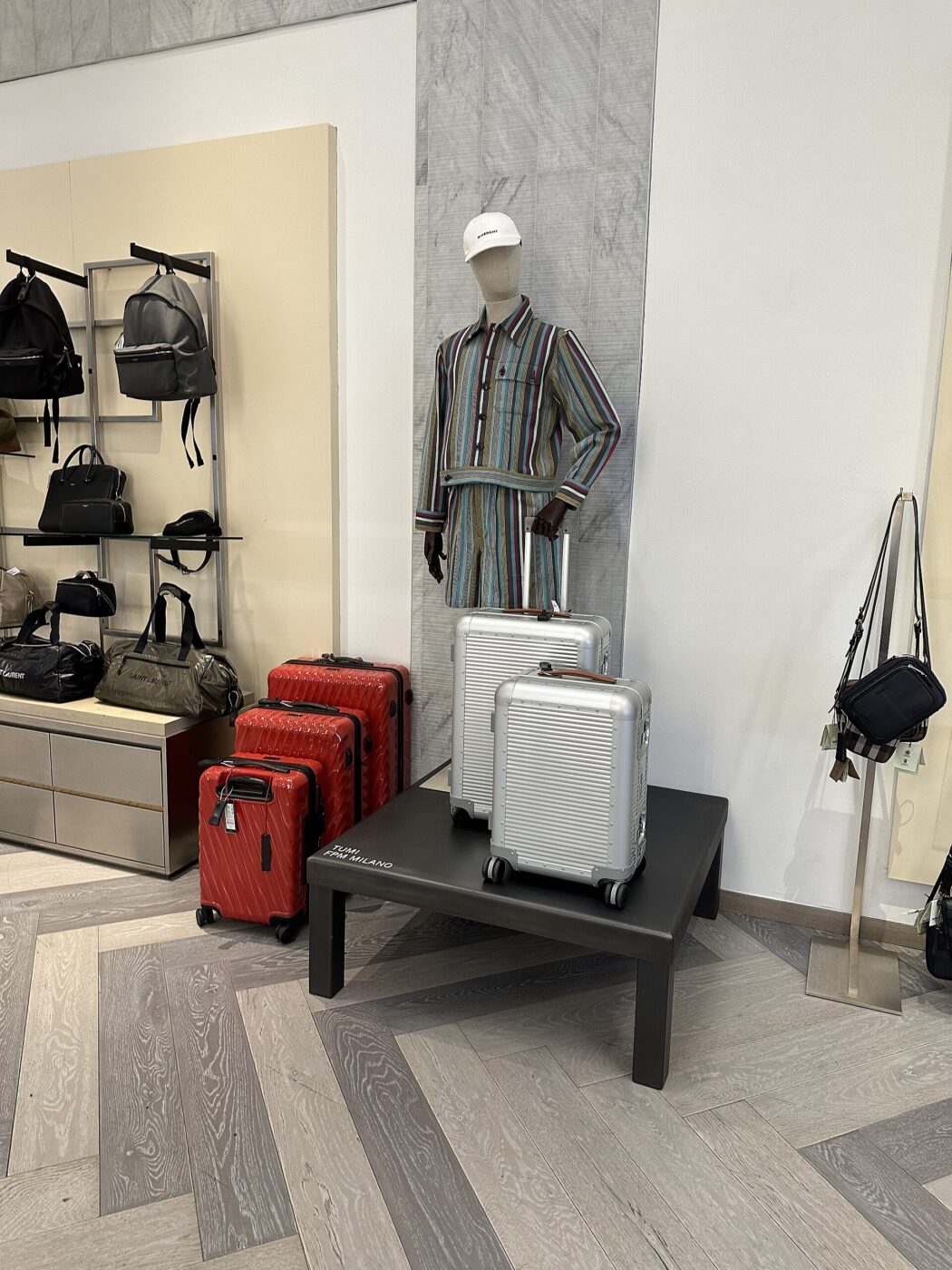 Hard-shell suitcases, backpacks and duffel bags displayed together in a retail store