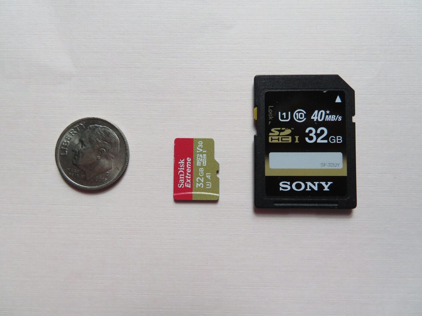 A US dime beside a microSD card and a full-size SD card for scale.