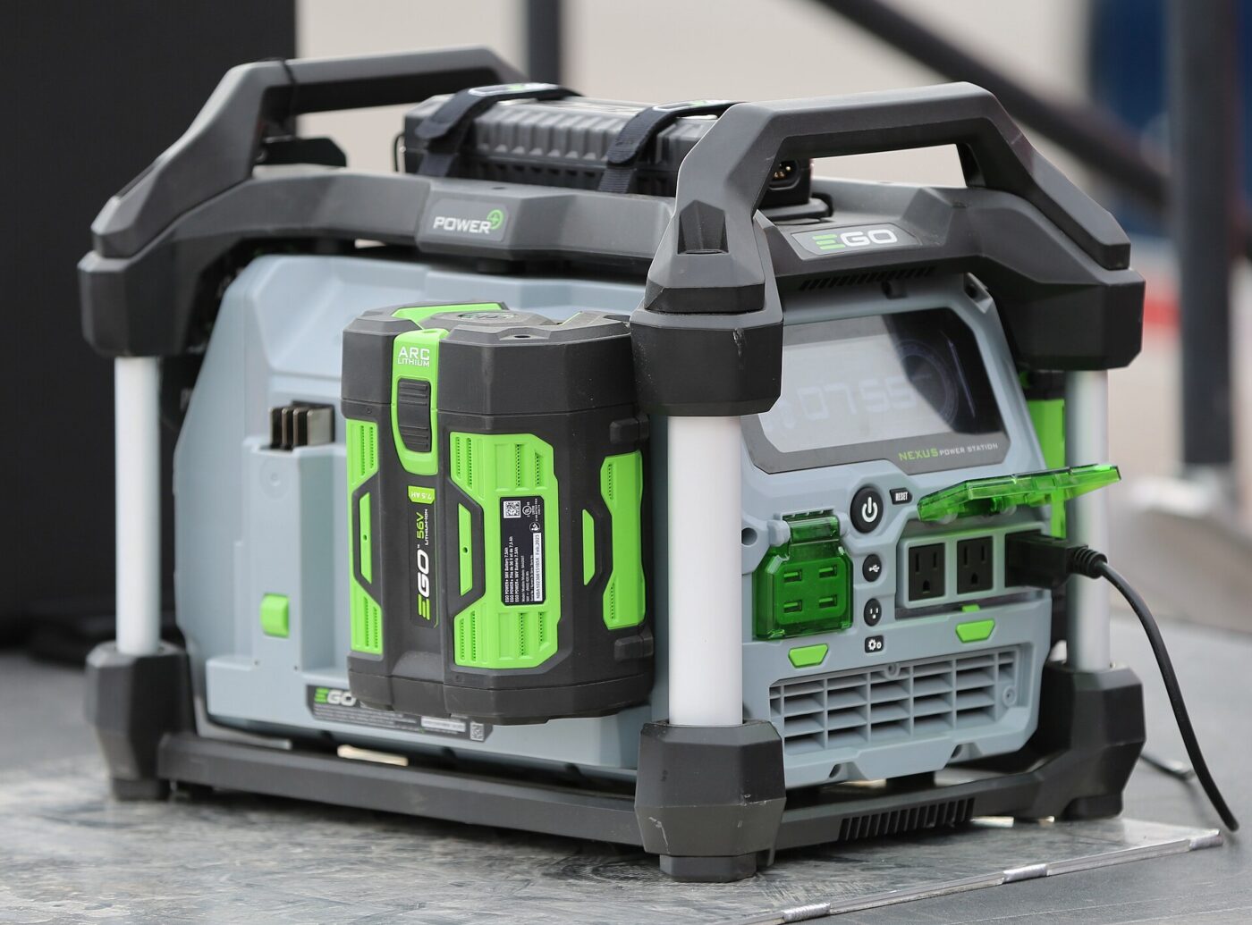 A portable power station with a swappable battery pack, household outlets and a power cord plugged in
