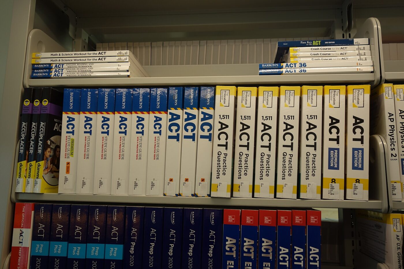 Library shelf lined with ACT prep guides and practice-question books from several publishers
