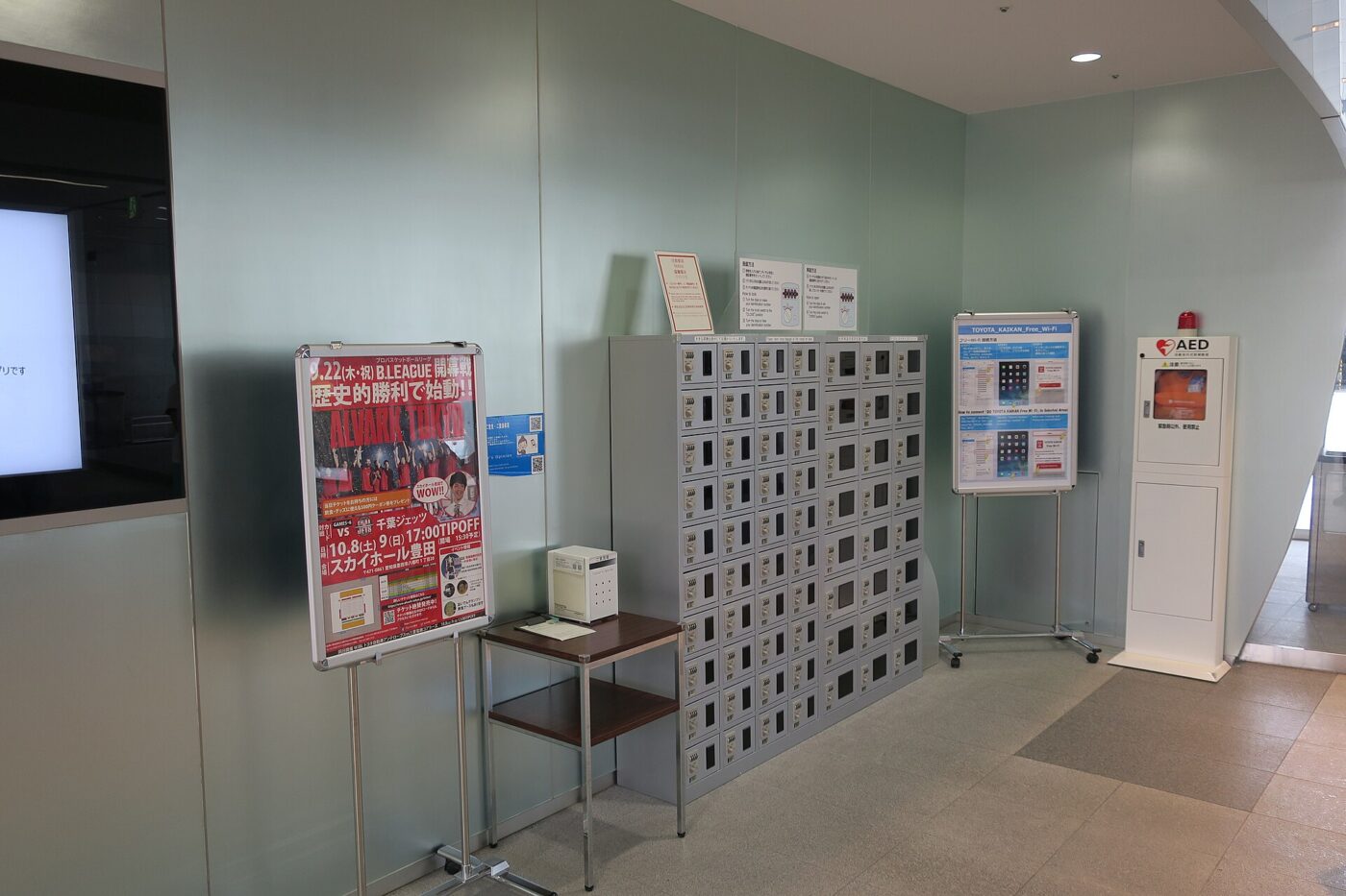 A bank of small numbered lockers for storing phones in a building lobby.