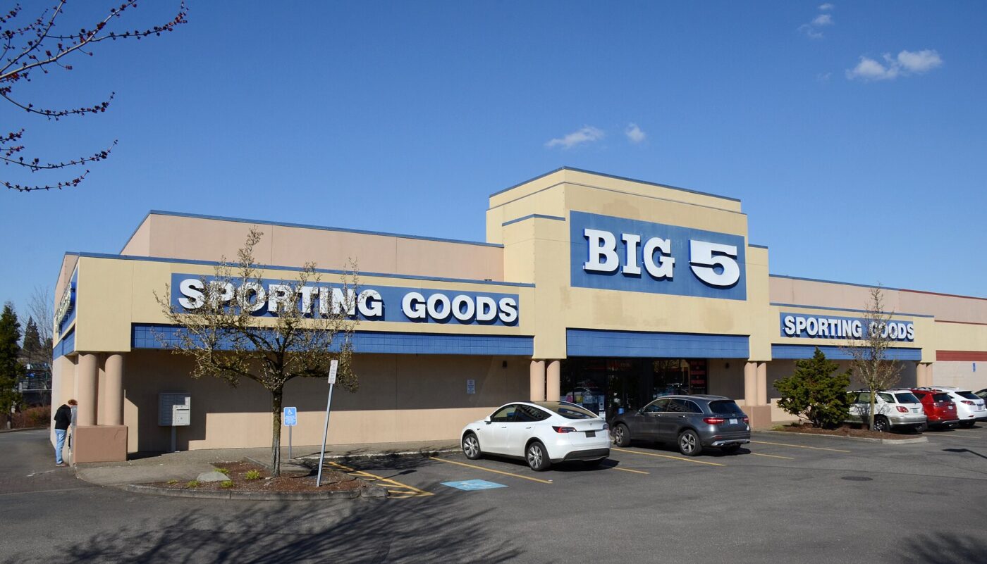 A Big 5 Sporting Goods store with cars parked out front on a clear, sunny day
