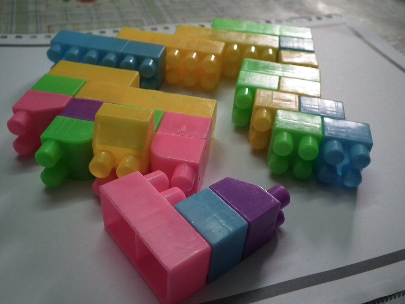 Large plastic building blocks in bright colors spread across a table.