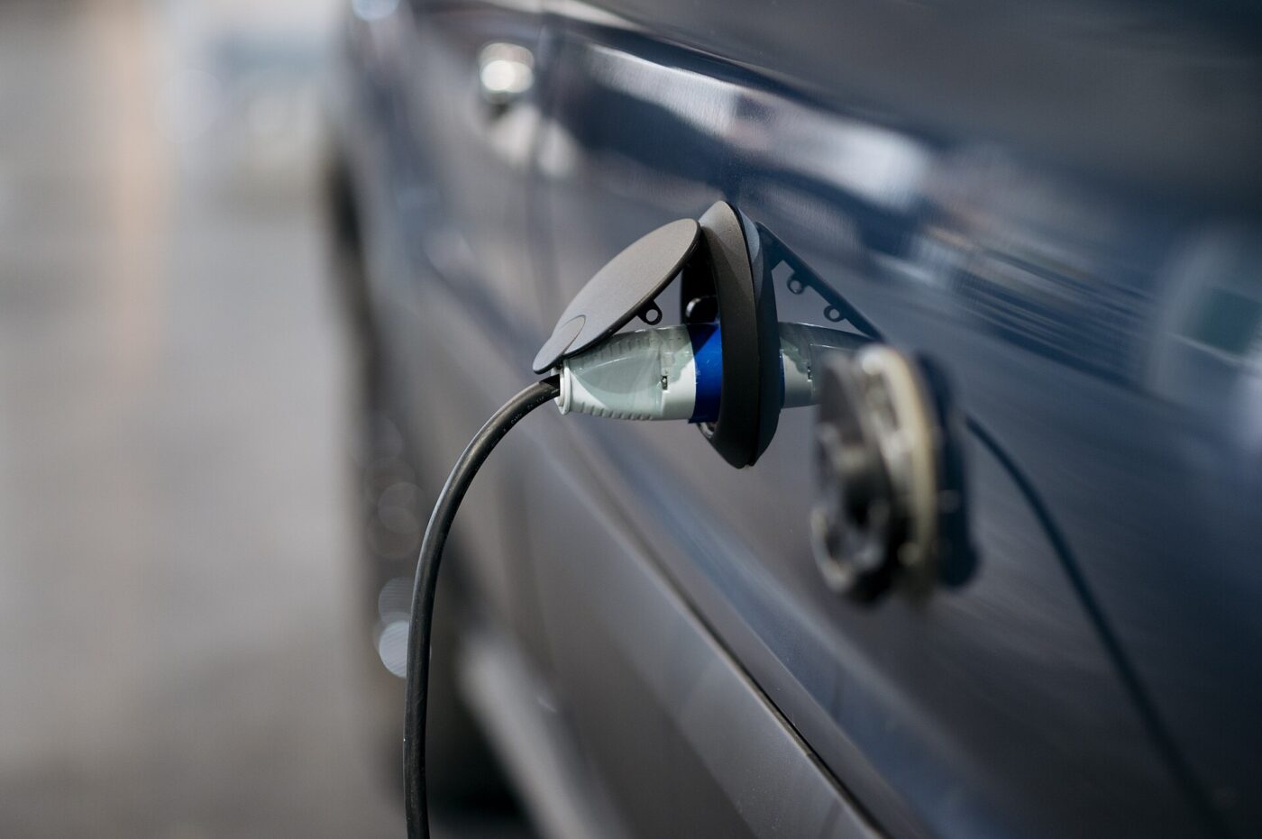 A charging cable plugged into the charging port of an electric car