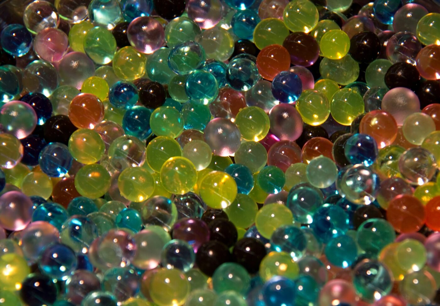 A dense layer of multicolored water beads, swollen and glossy after soaking.