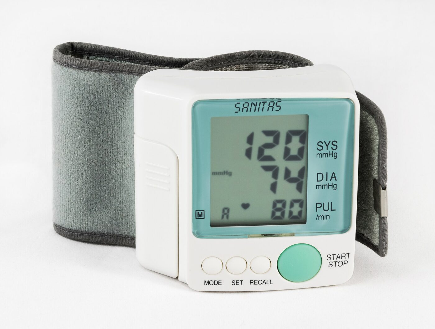 A wrist blood pressure monitor showing systolic, diastolic and pulse readings on its display