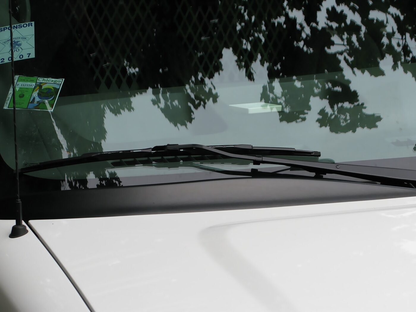 A pair of wiper blades parked at the base of a car's windshield