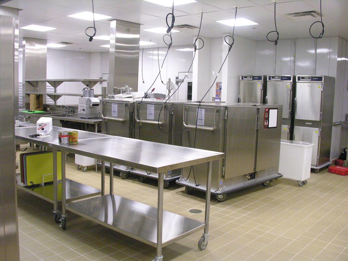 Stainless steel prep tables and equipment carts in a bright commercial catering kitchen