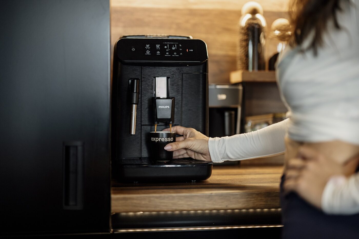 A countertop bean-to-cup espresso machine at the end of a wooden kitchen worktop.