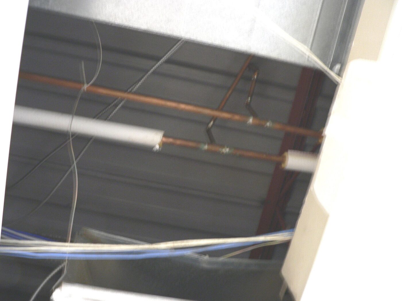 Copper water pipes, one run bare and one wrapped in foam insulation