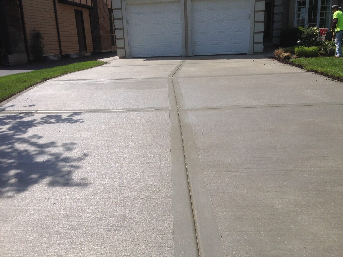 A finished residential concrete driveway running up to a garage