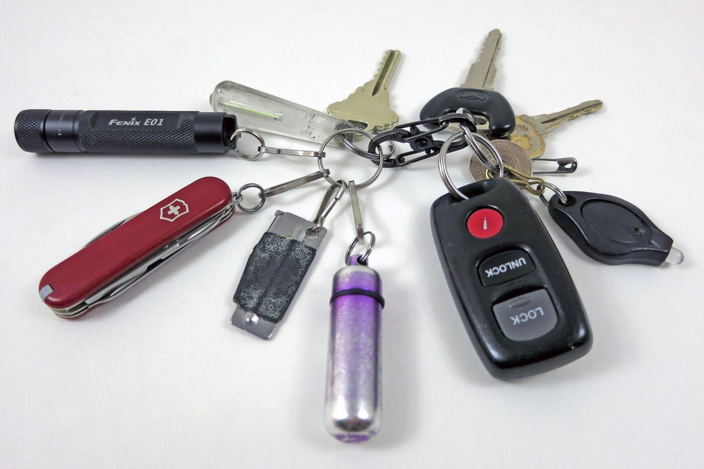 A keyring holding a small flashlight, a pocket knife, a memory stick and car keys.